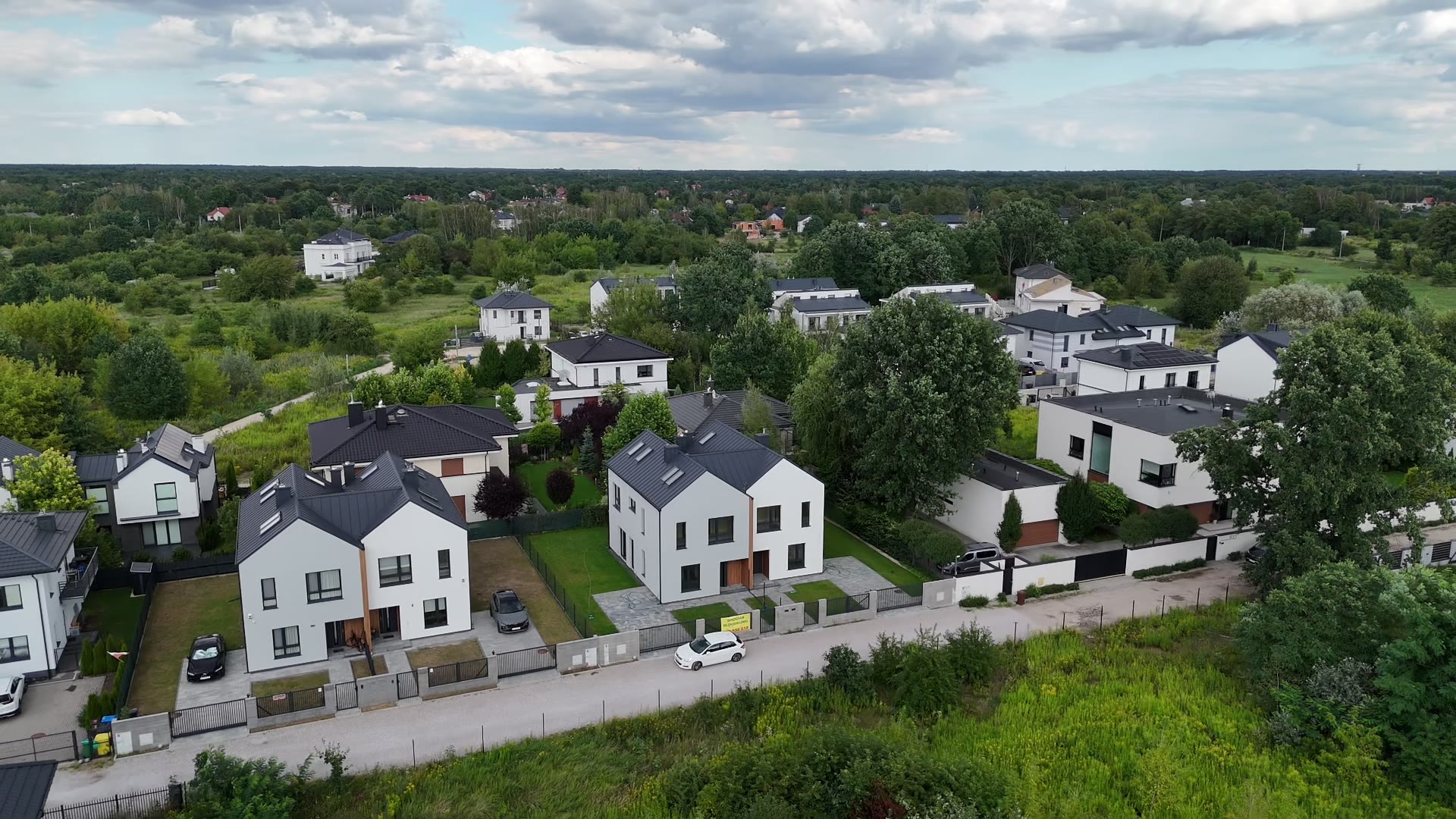 Widok z drona: bliźniaki inwestycji wśród zieleni Wawra, z lasem po horyzont